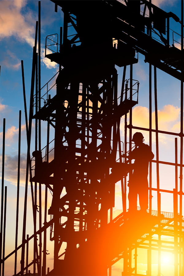 Ironworker installing structural steel beams during commercial construction.
