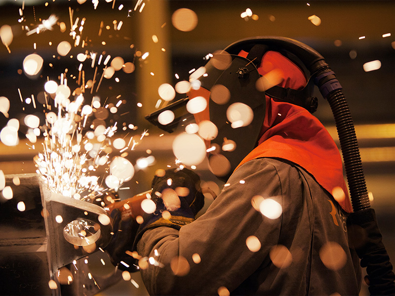 Field Welding Services | Geer Structural Construction Welder performing structural steel field welding during commercial construction.